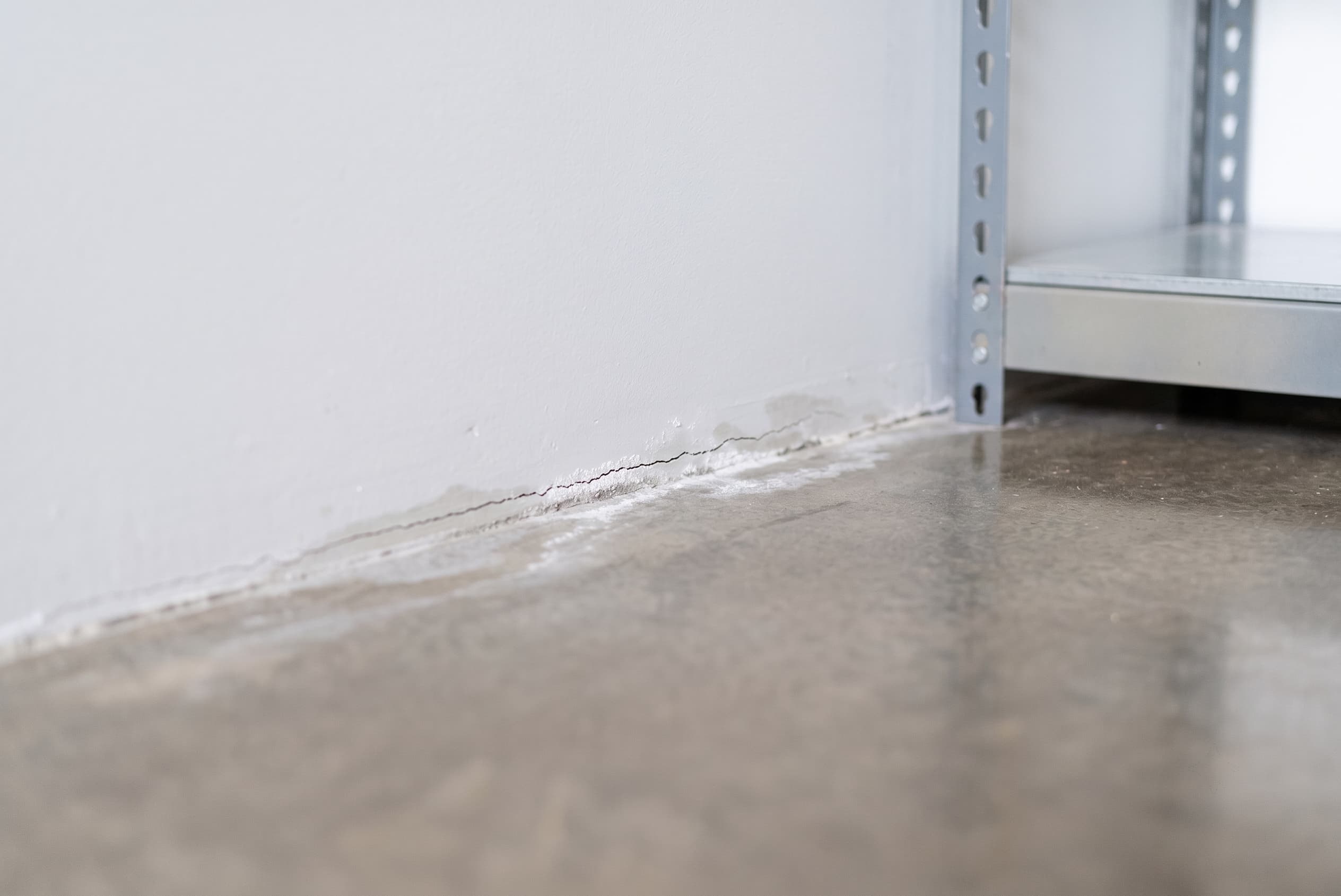 Signs of a slab leak in a Dallas home — wet floors and foundation damage